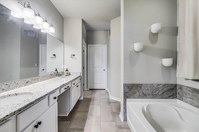 bathroom featuring tile patterned flooring, a bath, and vanity