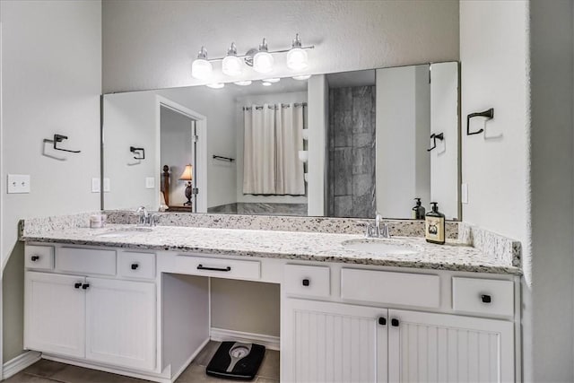 bathroom with tile patterned flooring, vanity, and walk in shower