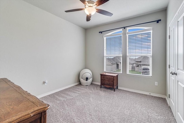 interior space with carpet flooring and ceiling fan