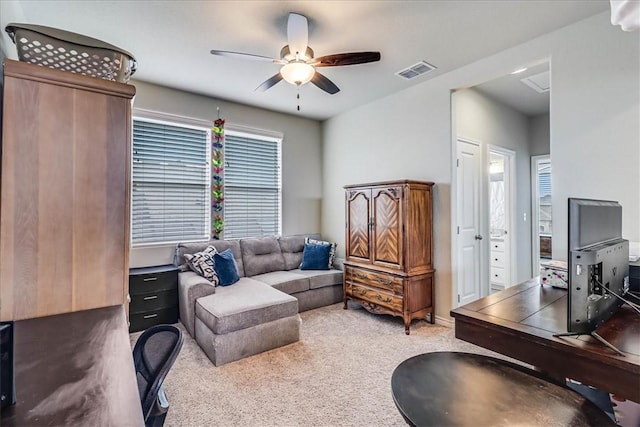 carpeted living room with ceiling fan