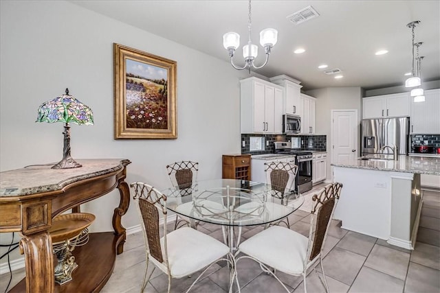 dining area with sink, light tile patterned flooring, and an inviting chandelier