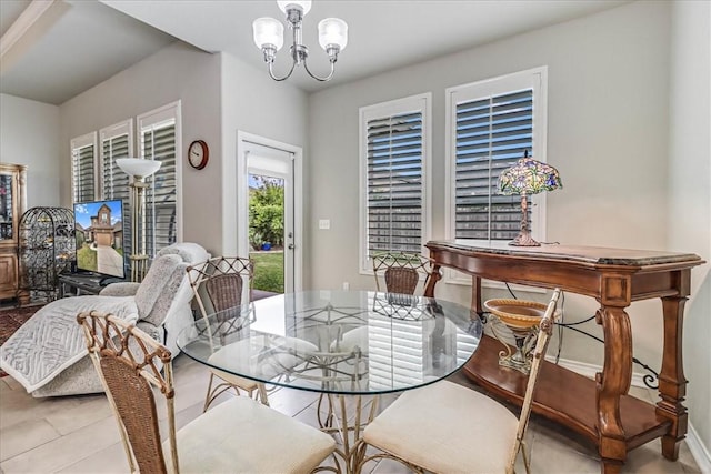 tiled dining room with a chandelier