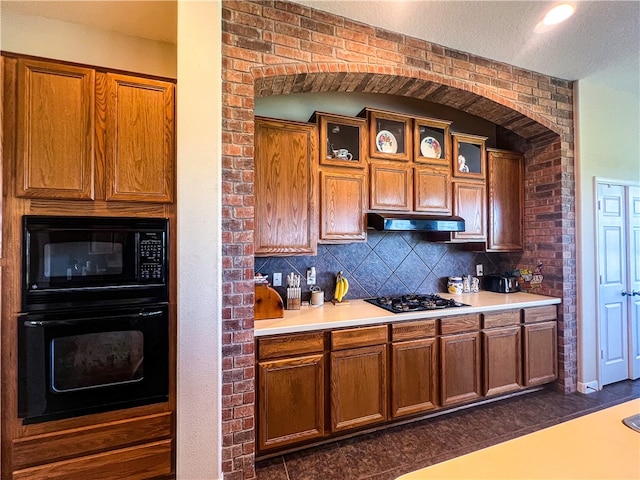 kitchen featuring a textured ceiling, backsplash, dark tile patterned floors, and black appliances