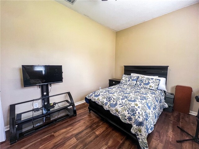 bedroom with lofted ceiling and dark hardwood / wood-style floors