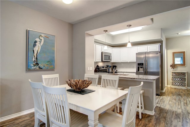 dining room with dark hardwood / wood-style flooring and sink