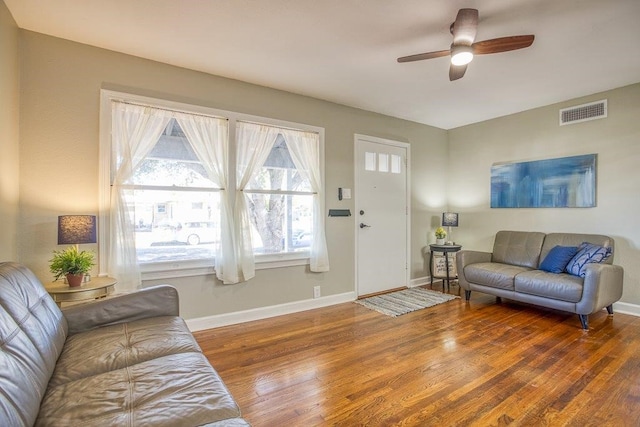 living room with ceiling fan and dark hardwood / wood-style floors