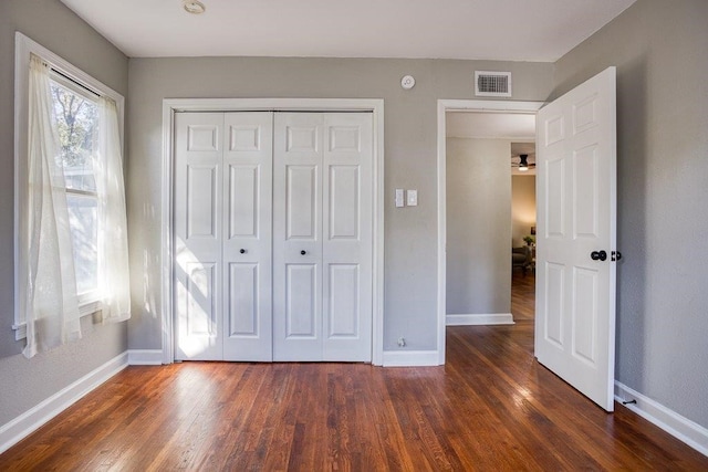 unfurnished bedroom featuring a closet and dark hardwood / wood-style flooring