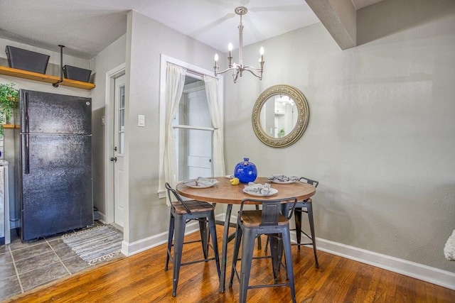 dining area with an inviting chandelier and dark hardwood / wood-style flooring