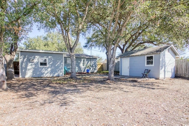 back of property with a storage shed