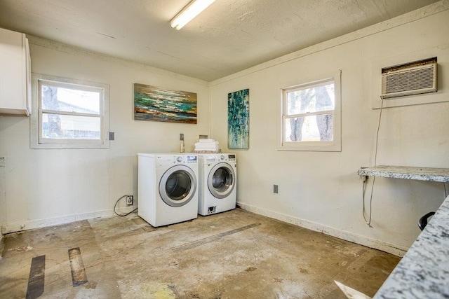 laundry area with a healthy amount of sunlight, a wall unit AC, cabinets, and independent washer and dryer