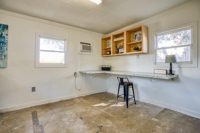 kitchen featuring plenty of natural light, a wall mounted AC, and a kitchen bar