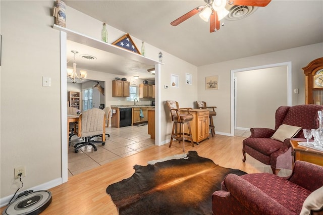 314 Inglewood, Ingleside, TX 78362 - living area with visible vents, baseboards, vaulted ceiling, light wood-style floors, and ceiling fan with notable chandelier