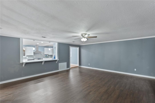 unfurnished living room featuring visible vents, dark wood-type flooring, ornamental molding, a ceiling fan, and baseboards