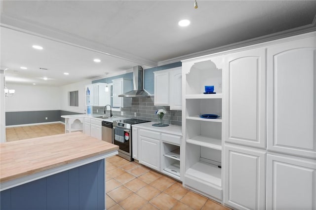 kitchen featuring open shelves, wall chimney exhaust hood, appliances with stainless steel finishes, and a sink