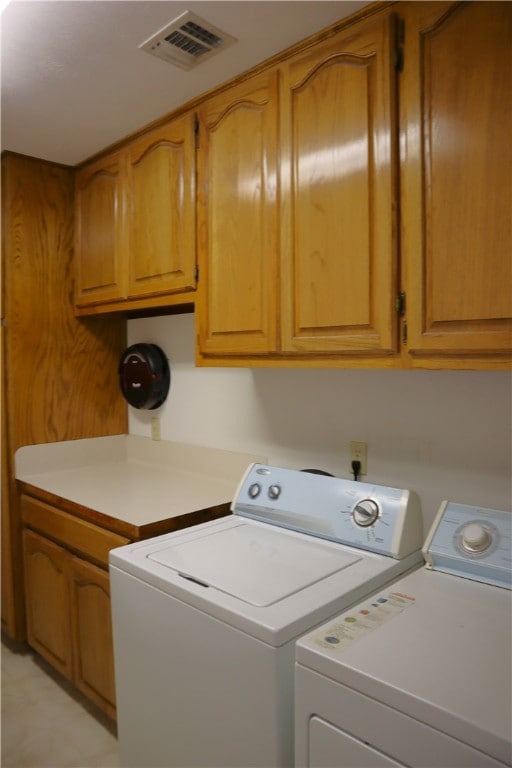 laundry room with washer and clothes dryer and cabinets