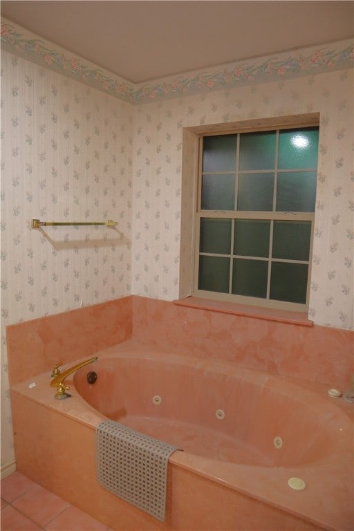 bathroom with a washtub and tile patterned flooring