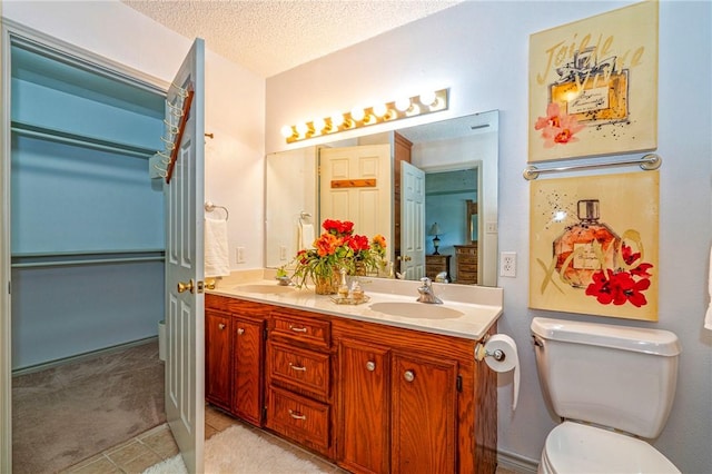 14613 Powell Dr, Corpus Christi, TX 78410 - full bathroom with double vanity, a textured ceiling, tile patterned floors, and a spacious closet