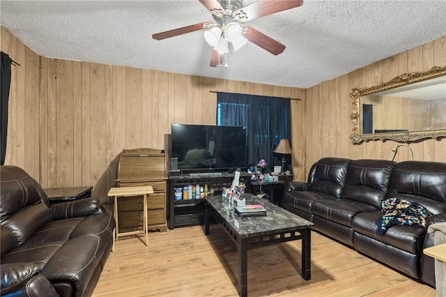 living room with wood walls, hardwood / wood-style floors, and a textured ceiling