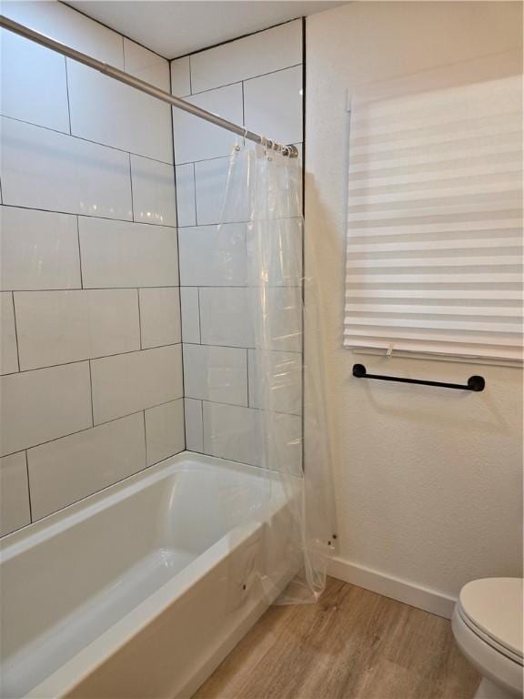 bathroom featuring hardwood / wood-style floors, toilet, and shower / bath combo with shower curtain