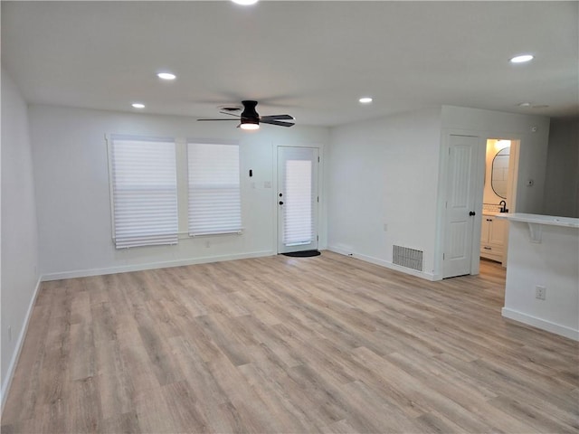 unfurnished living room featuring ceiling fan and light wood-type flooring