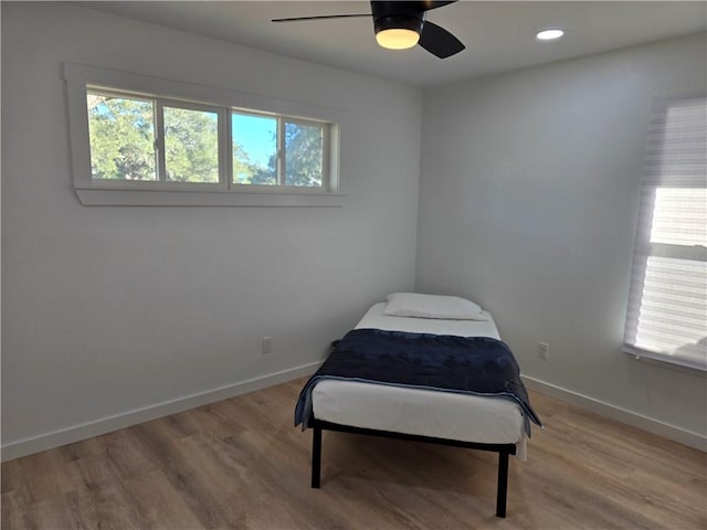 bedroom with light hardwood / wood-style floors and ceiling fan