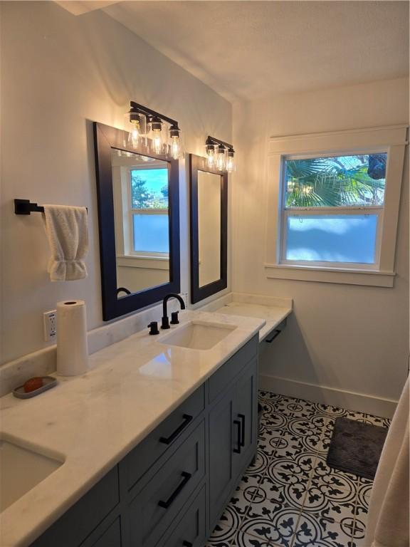 bathroom with tile patterned flooring, vanity, and a wealth of natural light