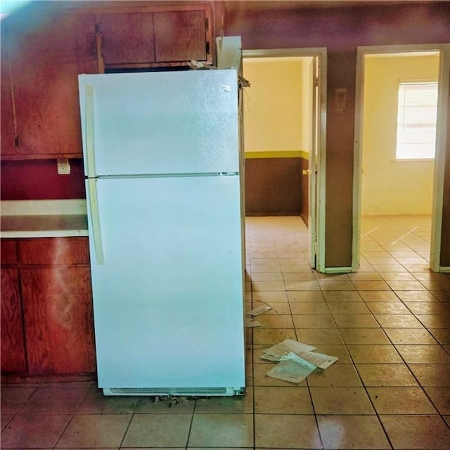 kitchen with light tile patterned floors, light countertops, and freestanding refrigerator