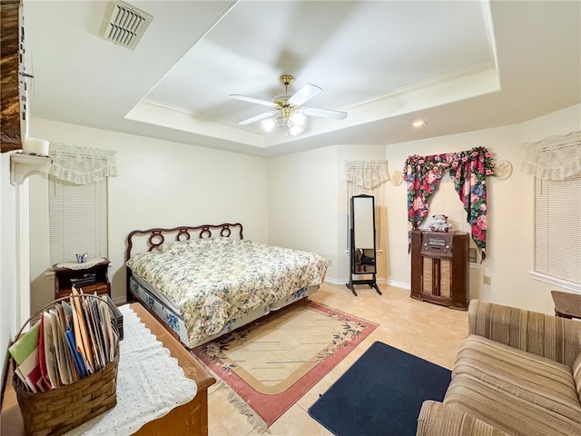 bedroom featuring ceiling fan, light tile patterned floors, crown molding, and a tray ceiling