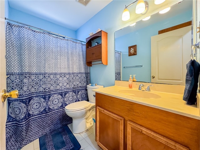 bathroom with toilet, vanity, and tile patterned floors