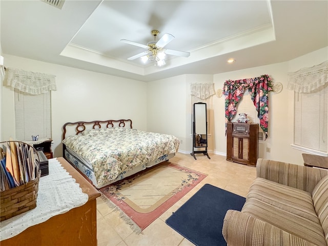 bedroom with light tile patterned flooring, ceiling fan, and a raised ceiling