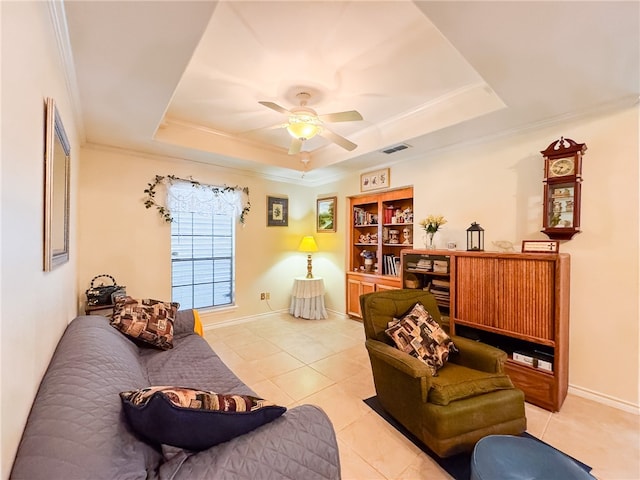 tiled living room featuring ceiling fan, crown molding, and a tray ceiling