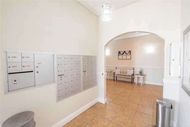 hallway with light tile patterned floors, mail boxes, and a high ceiling