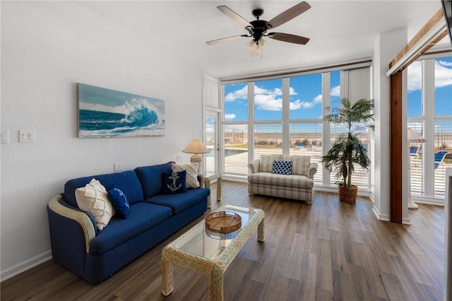 living room with ceiling fan, dark hardwood / wood-style floors, and a wall of windows