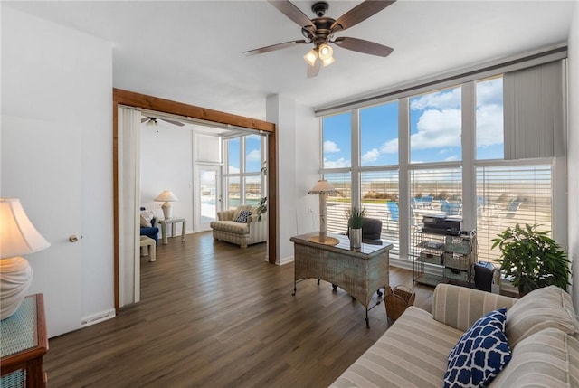 home office featuring ceiling fan, dark hardwood / wood-style floors, and a wall of windows