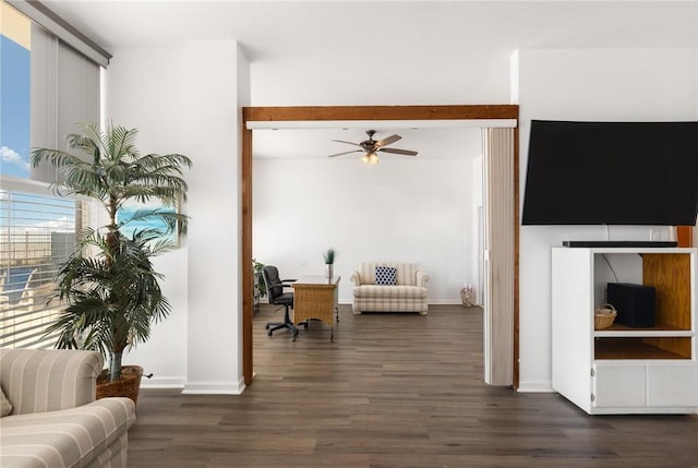 living room featuring dark hardwood / wood-style flooring, beamed ceiling, and ceiling fan