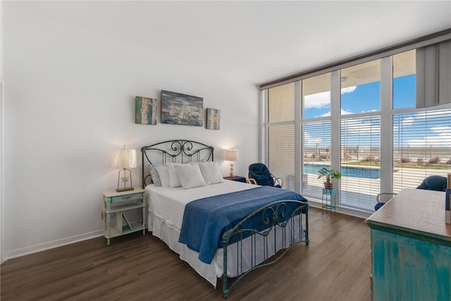 bedroom featuring dark wood-type flooring, expansive windows, and access to outside