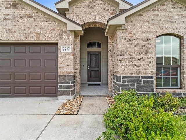 7717 Pruet Dr, Corpus Christi, TX 78414 - entrance to property with driveway, an attached garage, and stone siding