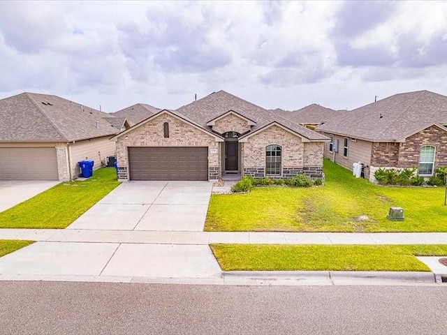 7717 Pruet Dr, Corpus Christi, TX 78414 - french provincial home featuring an attached garage, a front yard, concrete driveway, and brick siding