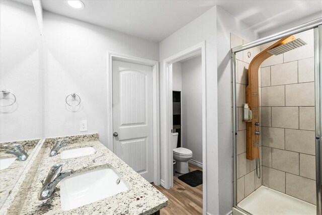 2673 Abbey Rd, Corpus Christi, TX 78415 - full bathroom featuring toilet, a shower stall, wood finished floors, double vanity, and recessed lighting