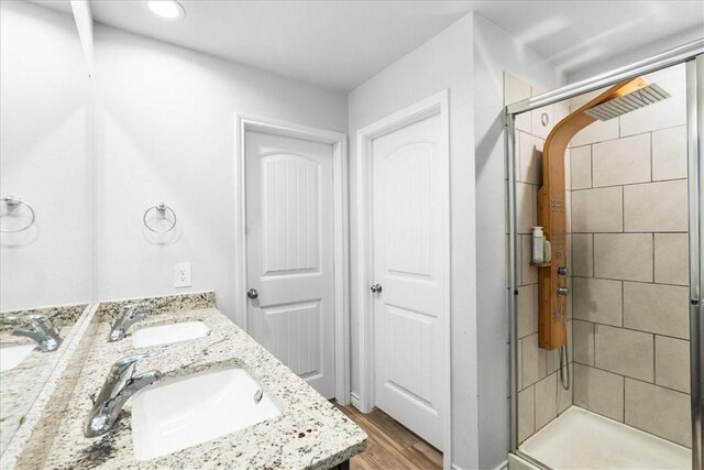 2673 Abbey Rd, Corpus Christi, TX 78415 - bathroom featuring a shower stall, double vanity, and wood finished floors