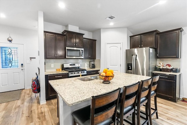 2673 Abbey Rd, Corpus Christi, TX 78415 - kitchen featuring stainless steel appliances, a breakfast bar, light wood-type flooring, dark brown cabinets, and recessed lighting