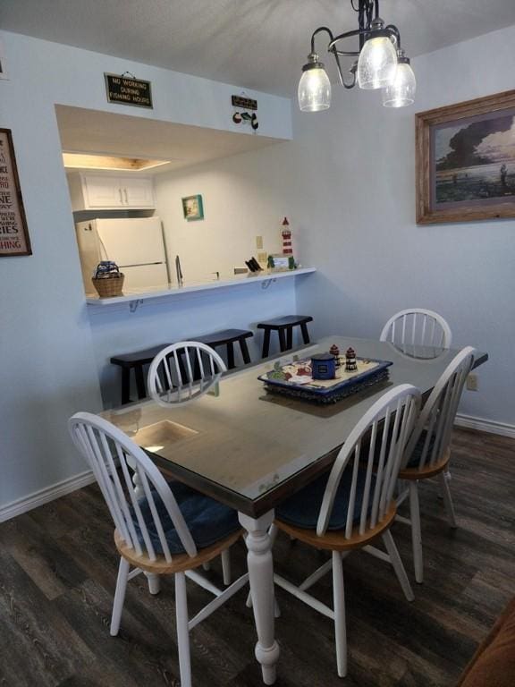 2292 N Fulton Beach Rd, Rockport, TX 78382 - dining space with dark wood-style floors, baseboards, and a chandelier