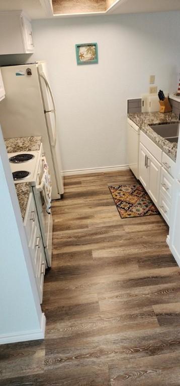 2292 N Fulton Beach Rd, Rockport, TX 78382 - kitchen featuring dark wood finished floors, white cabinetry, white appliances, and baseboards