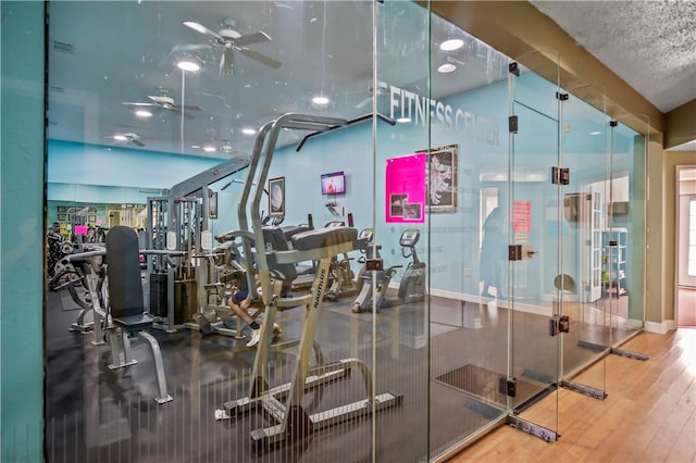 gym with wood-type flooring and ceiling fan