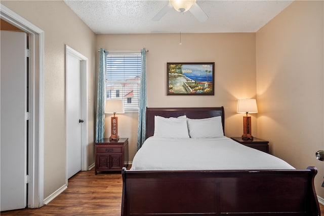 bedroom featuring ceiling fan, dark hardwood / wood-style floors, and a textured ceiling