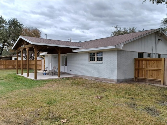 rear view of property with a lawn and a patio area