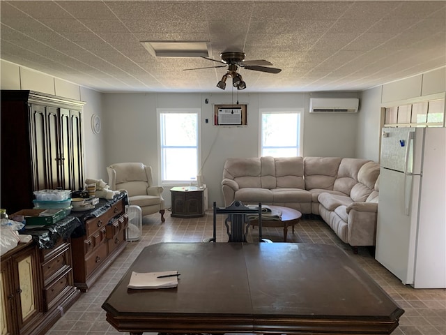 living room with an AC wall unit, ceiling fan, and a healthy amount of sunlight