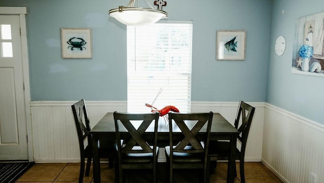 719 E King St, Rockport, TX 78382 - dining space with a wainscoted wall, tile patterned flooring, and plenty of natural light