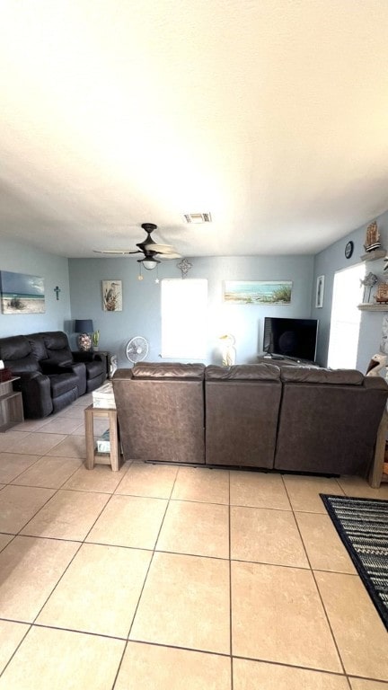 living room featuring ceiling fan, visible vents, and light tile patterned floors
