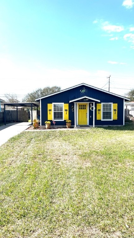 view of front facade with a front lawn, fence, and an attached carport